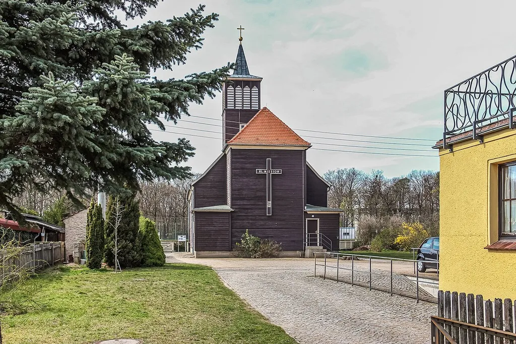Katholische Pfarrkirche St. Josef Niesky. Durch die Firma Christoph &amp; Unmack für Holz-Fertigteilhäuser als Sonderaufgabe in Niesky 1935 errichtet, Architekt Kurt Lange (Breslau); das querverschalte Schiff mit gotisierenden, spitz zulaufenden Fenstern wird dominiert durch einen integrierten kräftigen Glockenturm mit eingezogenem Pyramidendach; die Dachkonstruktion mit wohl speziell von Christoph &amp; Unmack entwickelten Industriebindern; baugeschichtlich und ortsgeschichtlich von Bedeutung