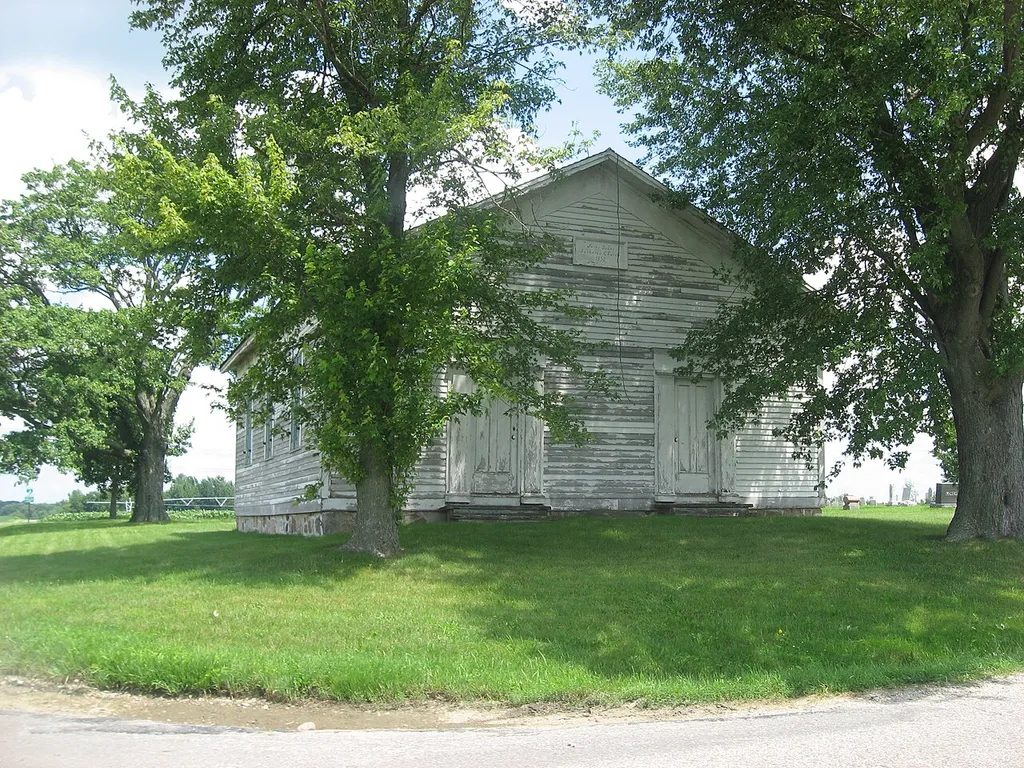 Front and western side of St. John's Lutheran Church, located on the northeastern corner of County Roads 15 and 32 west of Goshen in Harrison Township, Elkhart County, Indiana, United States. Built in 1853, it is listed on the National Register of Historic Places.