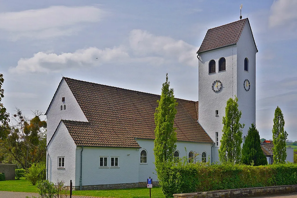 St.-Johannes-Kirche; rauh verputzter Massivbau unter Satteldach mit seitlichem Turm, erbaut 1954.