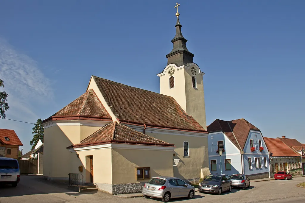 Die schlichte, barocke Saalkirche mit Westturm und nördlichem Sakristeianbau steht am östliche Ende der südlichen Platzfront.