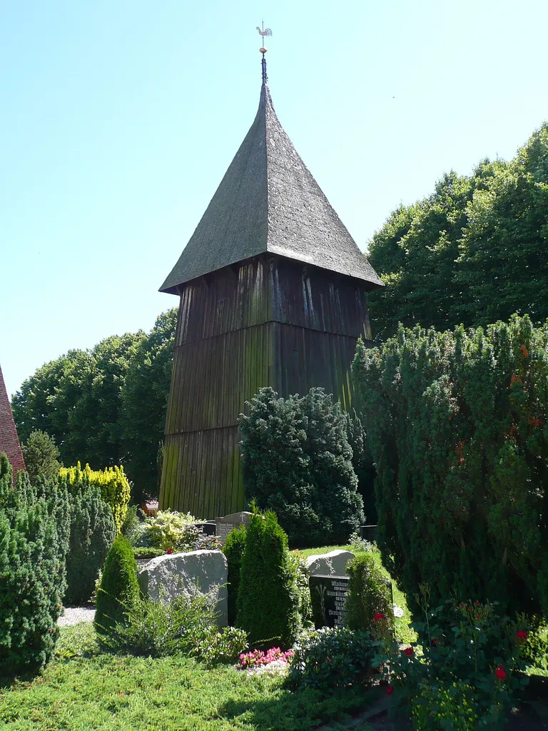 Glockenturm der Sankt-Petri-Kirche in Landkirchen auf Fehmarn. Der einige Meter von der Petrikirche entfernt stehende hölzerne Kirchturm wurde im Jahre 1638 errichtet.