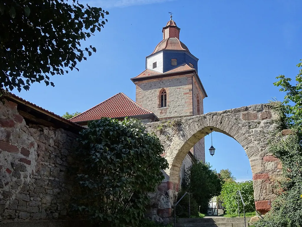 Ringgau-Röhrda im nordhessischen Werra-Meißner-Kreis. "Die Kirche erhebt sich an exponierter, erhöht liegender Stelle im Ortsbild in direkter Nachbarschaft zum Gutshof. Der erhaltene mächtige Westturm datiert in das Jahr 1508, der Turmaufsatz mit Haubenlaterne wurde um 1700 aufgesetzt. ... Der stattliche Außenbau besticht durch den hochaufragenden Turm, dessen Fachwerkaufbau die Ortssilhouette weithin bestimmt. Der das Gebäude umgebende Kirchhof bot mit seiner starken Ummauerung der Bevölkerung in Notzeiten sicheren Schutz." Text aus: Denkmaltopographie Bundesrepublik Deutschland, Kulturdenkmäler in Hessen. Werra-Meißner-Kreis I, Altkreis Eschwege. Peer Zietz, Thomas Wiegand, Braunschweig: Vieweg Verlag, 1991, ISBN 3-528-06240-1. Durch Röhrda führen der Herkules-Wartburg-Radwanderweg und der Elisabethpfad.