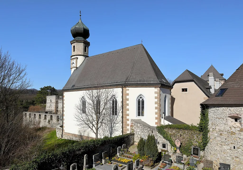 Südostansicht der röm.-kath. Pfarrkirche hl. Johannes Nepomuk in Neuhaus, ein Ortsteil der niederösterreichischen Marktgemeinde Weissenbach an der Triesting.Die Kirche wurde um 1605 als protestantische Schlosskapelle gebaut und wurde im Zuge der Josephinischen Reformen 1783 zur röm.-kath. Pfarrkirche erhoben.