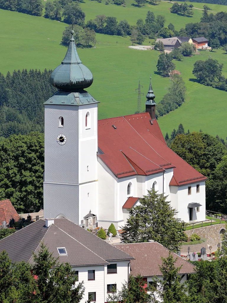 Südwestansicht der röm.-kath. Pfarrkirche hl. Leonhard in St. Leonhard am Wald, ein Ortsteil der niederösterreichischen Stadtgemeinde Waidhofen an der Ybbs.Die weithin sichtbare in erhöhter Lage errichtete Kirche ist eine spätgotische Hallenkirche mit einem leicht eingezogenen Chor. Der mächtige vorgestellte Westturm stammt aus dem 15. Jahrhundert und hat eine barocke Haube.