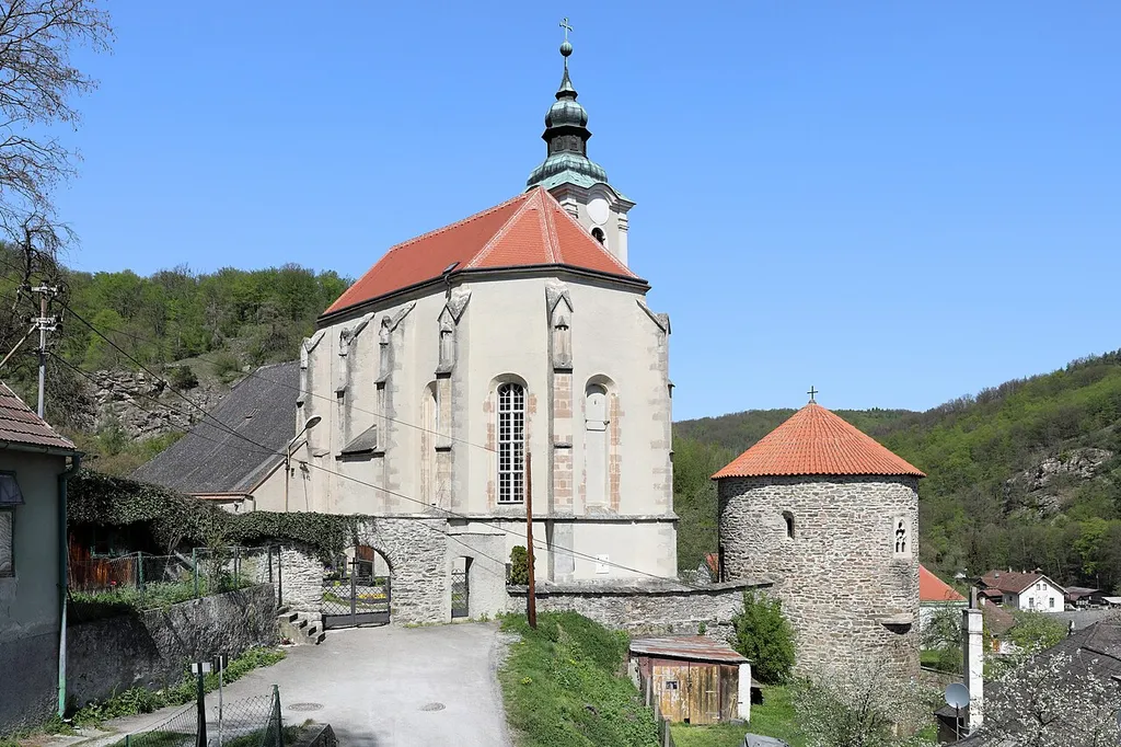 Die röm.-kath. Stadtpfarrkirche hl. Veit in der niederösterreichischen Stadt Hardegg und rechts davor der Karner.Die Kirche besteht aus einem romanischen Langhaus, einem hochgotischen Chor (um 1400), sowie einem barocken Turm aus dem Jahr 1754 und wurde ab 1743 barockisiert. Der Karner, ein unverputztes, aus Bruchsteinen romanisches Rundbauwerk mit stumpfem Kegeldach, wurde in der Zeit zwischen 1150 und 1160 errichtete.