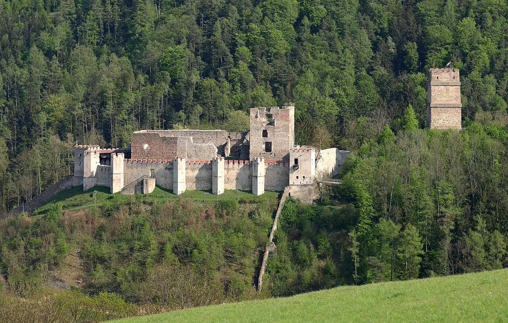 Nordwestansicht der Burgruine in der niederösterreichischen Stadt Kirchschlag in der Buckligen Welt. Rechts der durch einen Halsgraben von der übrigen Burganlage getrennte Bergfried und der heutzutage als Aussichtsturm genutzt wird.