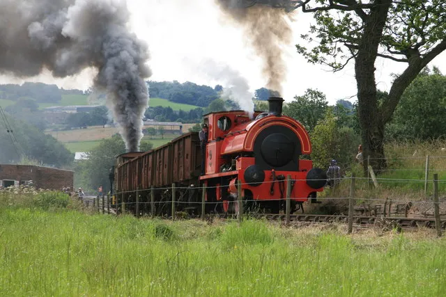 Foxfield Railway - tackling the bank. In a noisy and volcanic performance a rake of wagons is hauled by Bagnall No. 2 of 1946 and banked by Dubs crane tank No. 4101 of 1901. This was at the Summer Steam Gala 2012.