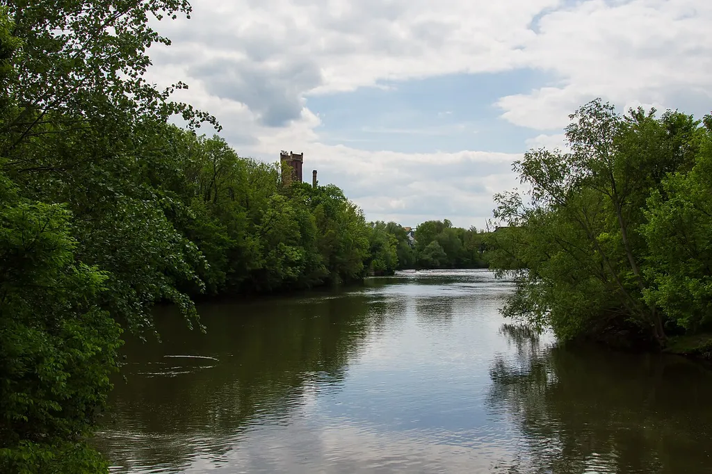 Blick von einer Brücke auf die wilde Saale im Naturschutzgebiet Rabeninsel Halle (Saale) - mit alter Papiermühle im Hintergrund links.