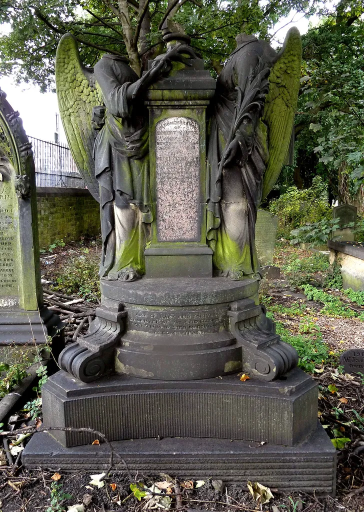 Mawer memorial, dedicated to the sculptor Robert Mawer (1807-1854), in the churchyard of St Mark's Church, Woodhouse, Leeds, West Yorkshire. This is a Grade II listed monument, no. 1256146. Mawer's wife and son wer both sculptors, but it is probably carved by his wife Catherine for the following reasons: (1) Her name has been added later, by a different hand, and the names of her relatives who died before she did, have been added (but not his relatives); (2) The back of the monument features a garland which Robert and Catherine carved on St George's Hall, Bradford, and on Moorlands House, Leeds; (3) When Robert Mawer died, their son Charles was aged 16, just beginning his apprenticeship. The inscriptions on the monument say: "In remembrance of Robert Mawer, who died November 10th 1854, aged 47 years. Also Catherine Mawer, wife of the above, who died April 11th 1877, aged 74 years." "Also of Elizabeth Scriven, mother in law of the above, who died December 2nd 1841, aged 74 years." "Also of Mary Ann Scriven, daughter of the said Elizabeth Scriven, who died March 15th 1861." Note: Between 1997 when the monument was listed, and 2015 when it was photographed by Geograph, the urn on the column and the heads of the two angels were removed.