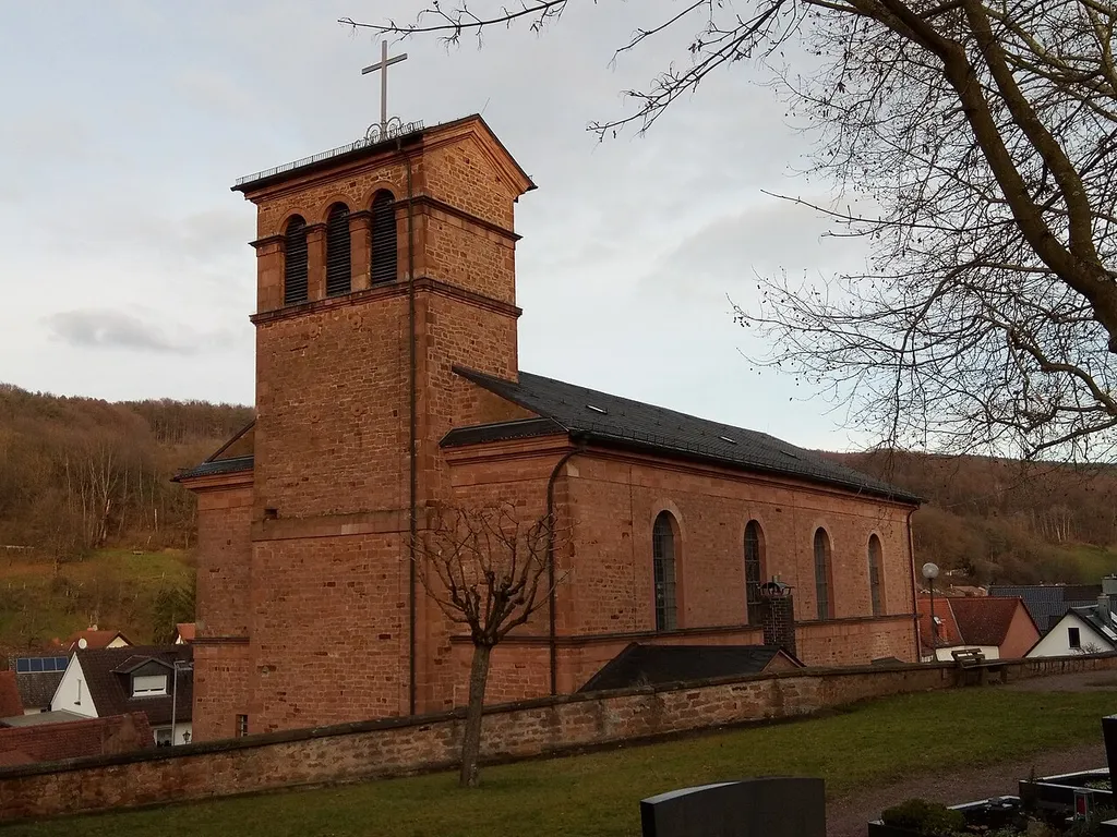 Katholische Pfarrkirche St. Jakob, Saalkirche mit Rundapsis innerhalb des leicht vor die Fassade tretenden Rechteckturmes, Satteldachbau mit unverputztem sparsam gegliedertem Sandsteinmauerwerk, Turm mit Rundbogenschallarkaden und Flachsatteldach, klassizistisch, 1819–22, durchgreifender Umbau 1839, Erweiterung 1937/38; mit Ausstattung