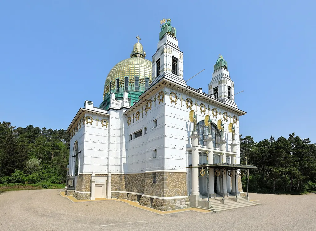 Südansicht der Kirche am Steinhof, auch Leopoldskirche bezeichnet, auf dem Gelände des „Sozialmedizinischen Zentrums Baumgartner Höhe“, mittlerweile als Klinik Penzing bezeichnet, im 14. Wiener Gemeindebezirk Penzing.Die Kirche wurde von 1904 bis 1907 über dem traditionellen Grundriss eines griechischen Kreuzes nach Plänen des Architekten Otto Wagner als Anstaltskirche errichtet. Sie ist der bedeutendste Sakralbau der Wiener Moderne in Wien.