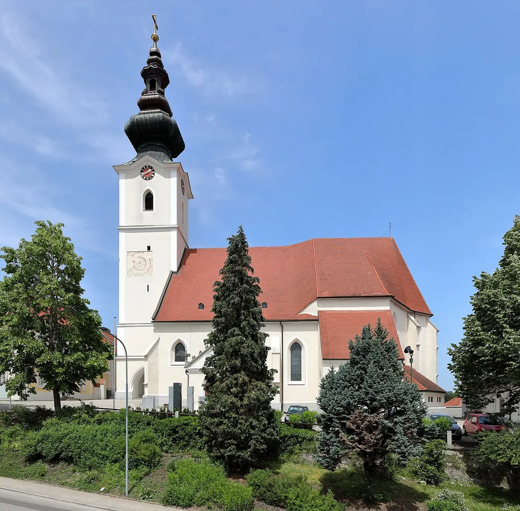 Südansicht der röm.-kath. Pfarrkirche hl. Martin in der niederösterreichischen Marktgemeinde Aschbach-Markt. Eine spätgotische Staffelkirche aus dem 15./16. Jahrhundert, wobei der vorgestellte Westturm 1833 erhöht wurde und eine vierfache Zwiebelhaube mit Laterne erhielt.
