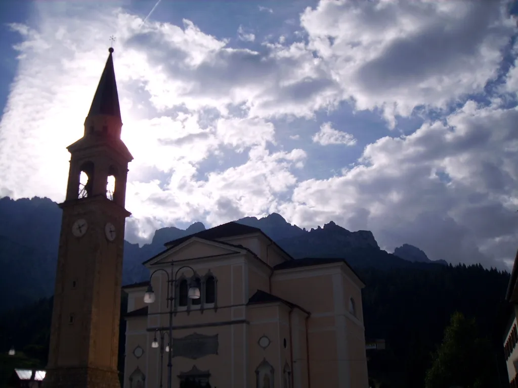 Silhouette of bell tower, clouds and mountains in Padola part of Comelico Superiore, province of Belluno, Dolomites, Italy