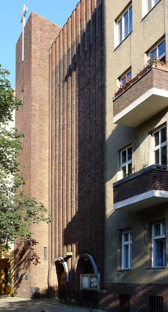 Straßenfront der Kirche mit daneben liegendem Pfarrhaus