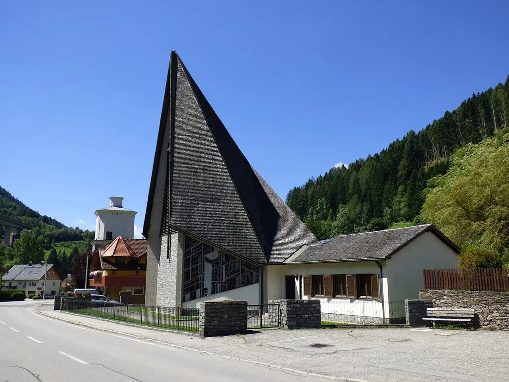 Katholische Pfarrkirche Christus Friedenskönig in Eisentratten, Gemeinde Gmünd in Kärnten. im Hintergrund: Konstantin-Hochofen