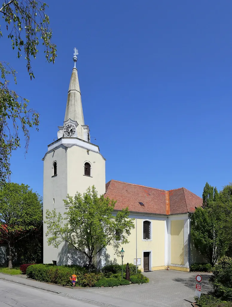 Südwestansicht der römisch-katholischen Pfarrkirche hl. Laurentius der niederösterreichischen Marktgemeinde Drösing.Die barocke Kirche wurde 1796 anstelle der wegen Baufälligkeit abgebrochenen Vorgängerkirche errichtet. Der romanische Kirch- und Wehrturm der Vorgängerkirche (Ende 13. Jahrhundert) wurde in den Neubau miteinbezogen und teilweise barockisiert.