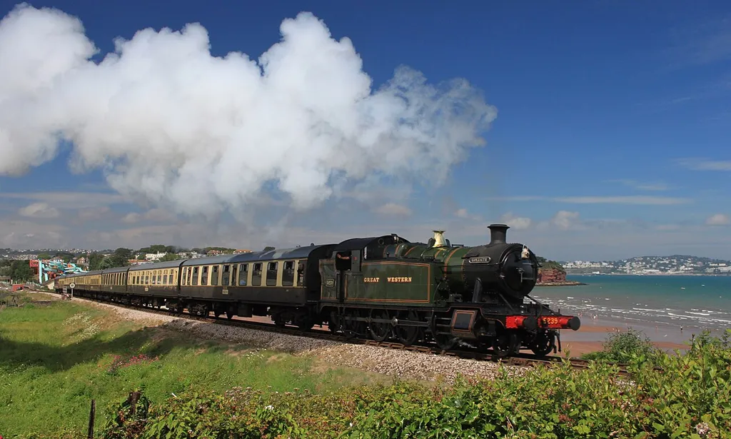 Former Great Western Railway 2-8-0T 5239, which now carries the name Goliath, climbs up above Goodrington Sands as it heads for Kingswear on the Dartmouth Steam Railway in Devon.