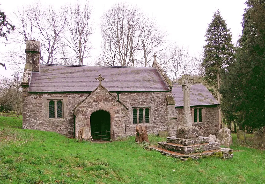 St Peter's parish church, Llancillo, Herefordshire, seen from the southeast. The churchyard cross (right) is separately listed.