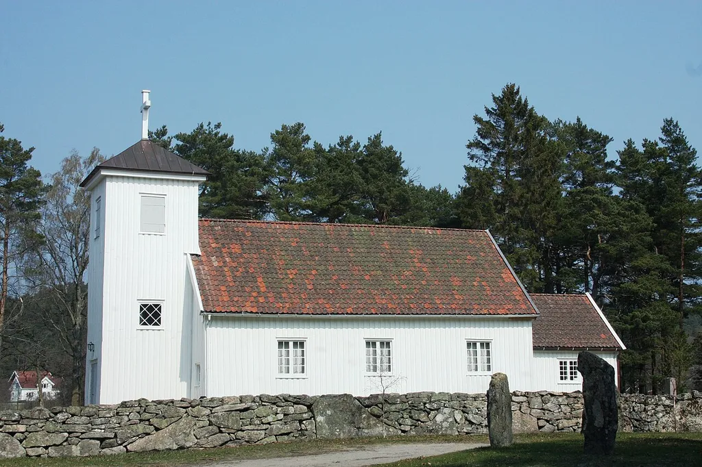 Harkmark Church in Mandal municipality, Norway. One of the oldest church grounds in Agder, with viking-age bauta stones seen in the foreground.