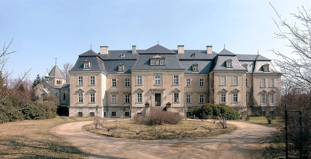 08.04.2006 02633 Gaußig: Schloß und links die Schloßkapelle. Das Schloss geht auf Rudolph von Neitschütz zurück, der den barocken Bau um 1700 errichten ließ. 1747 ging der stark verschuldete Besitz an Heinrich Graf von Brühl (von 1746 bis 1751 kurfürstlich-sächsischer und königlich-polnischer Premierminister) über. Graf Brühl trug eine der reichsten Gemäldesammlungen der Lausitz zusammen. Zur Begleichung von Schulden wurde die Sammlung an die Zarin von Rußland, Katharina die II., verkauft und bildete den Grundstock für die Ermitage in Leningrad. 1750 folgte Hermann Carl Graf von Keyserling. Sein Name verbindet sich mit den berühmten Goldberg-Variationen. 1766 kaufte Peter Graf von Riaucour das Rittergut Gaußig. Ende des 18. Jh. wurde d. Schloß im klassizistischen Stil von Ch. F. Schuricht umgestaltet. In der DDR Erholungsheim der TU Dresden. Nach der Wende wurde das Inventar an Wilderich von Schall-Riaucour zurückgegeben. Dieser hat d. Großteil des Inventars 1998 versteigern lassen. Das Schloss gelangte an eine irische Gesellschaft, die einen Business-Club einrichten wollte, was nie erfolgte. Statt dessen verfielen Schloss und Park zusehends. Der Freistaat Sachsen übertrug nun Schloss und Park 2004 an Andreas Graf von Brühl-Pohl. Andreas Graf von Brühl-Pohl, seine Gattin Marlies und die zwei Söhne haben den Adelssitz vorbildlich restauriert. [DSCN9378-9380.TIF]20060408065MDR.JPG(c)Blobelt
