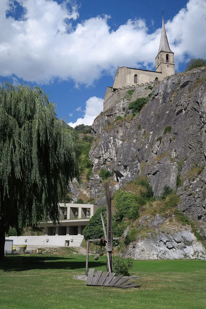 The underground church St. Michael of Raron is located under the rock of the castle church. The bells are above the entrance area. Switzerland, Aug 8, 2016. (1/7) >