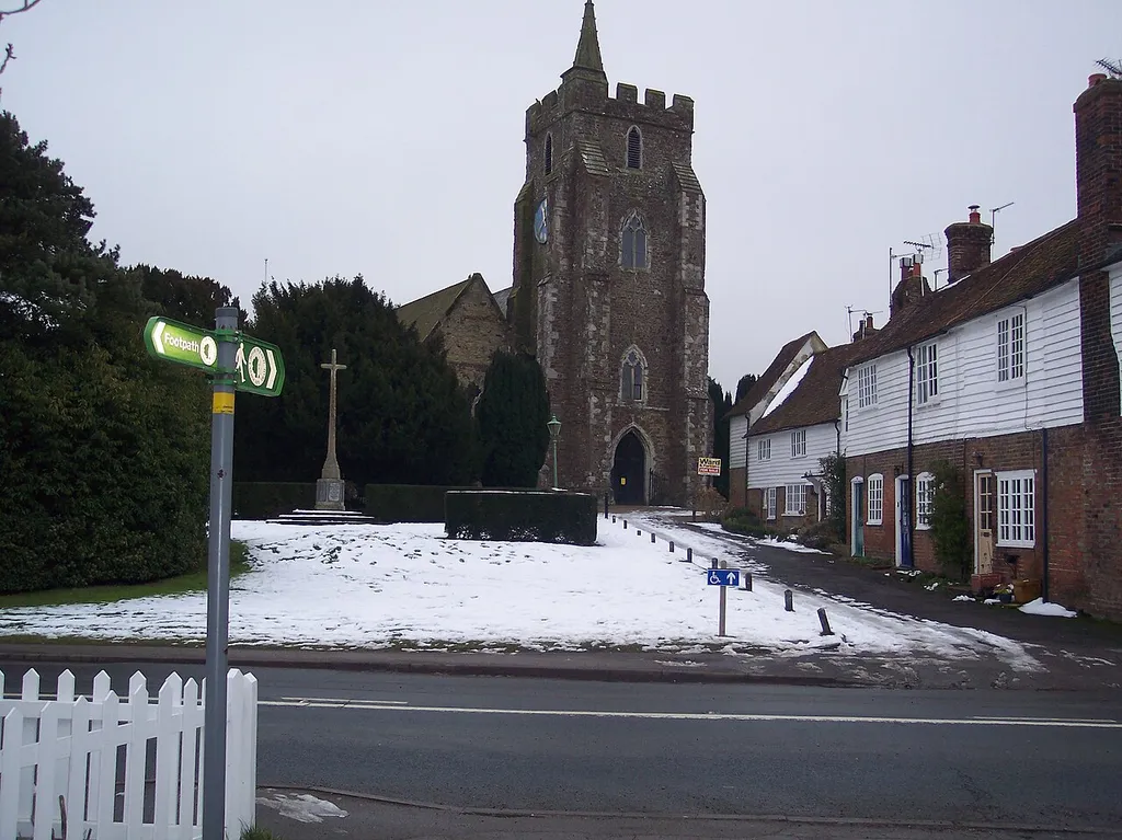 The High Weald Landscape Trail crosses Rolvenden High Street The long distance path crosses the road then along Church Row, towards St.Mary the Virgin, Church and then heading towards Great Maytham. In the background is the War Memorial.