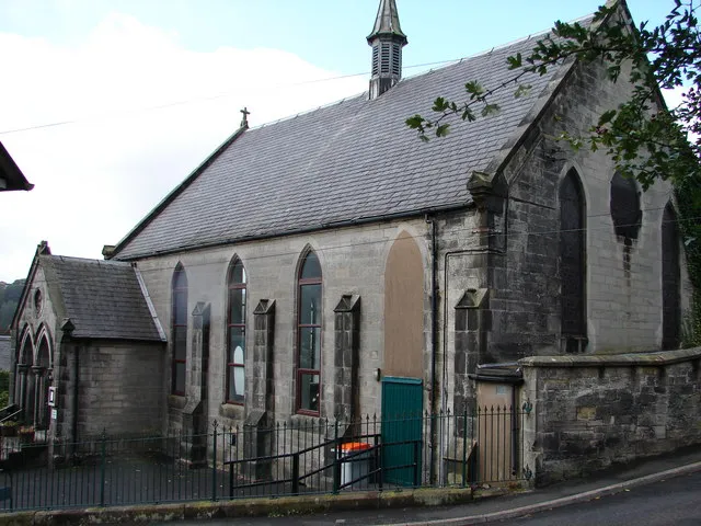 St Francis of Assisi RC Church, Langholm Formerly Langholms South United Presbyterian Church built in 1884; it is a plain buttressed rectangle with a lead spire. This was a difficult subject to photograph due to the confined space in a narrow street.