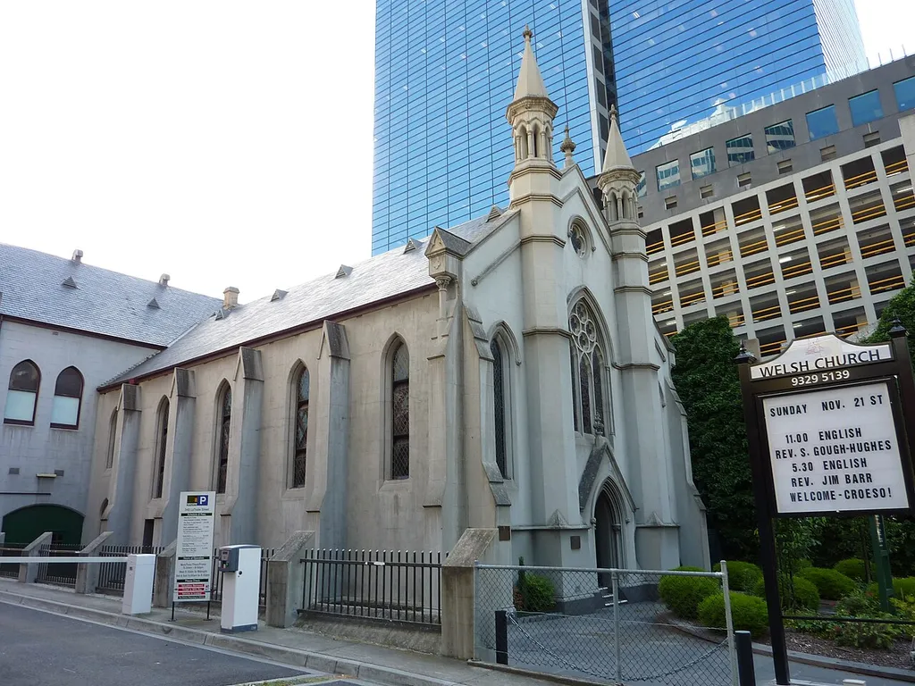 Welsh Church located on La Trobe Street, Melbourne. Sign beside church. Buildings in background.