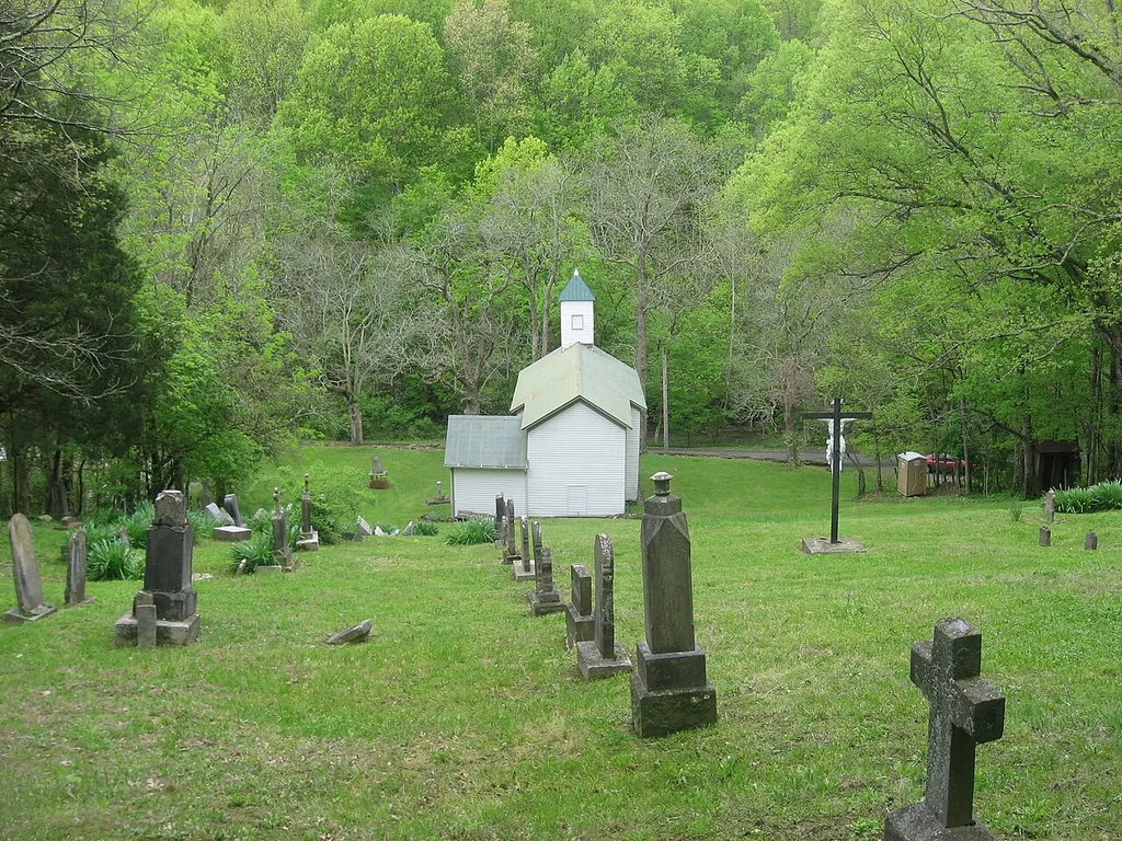 View of Immaculate Conception Catholic Church from its hillside cemetery; the church sits at the base of a steep hill along Stepstone Road east of Peach Grove in Pendleton County, Kentucky, United States. Built in 1860, the church and its cemetery are together listed on the National Register of Historic Places.