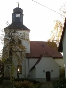 Kirche (mit Ausstattung), Kirchhof mit Denkmal für die Gefallenen des 1. Weltkrieges und einige alte Grabmale, darunter in die Kirchhofsmauer eingelassene Grabanlagen Schönauer Straße -