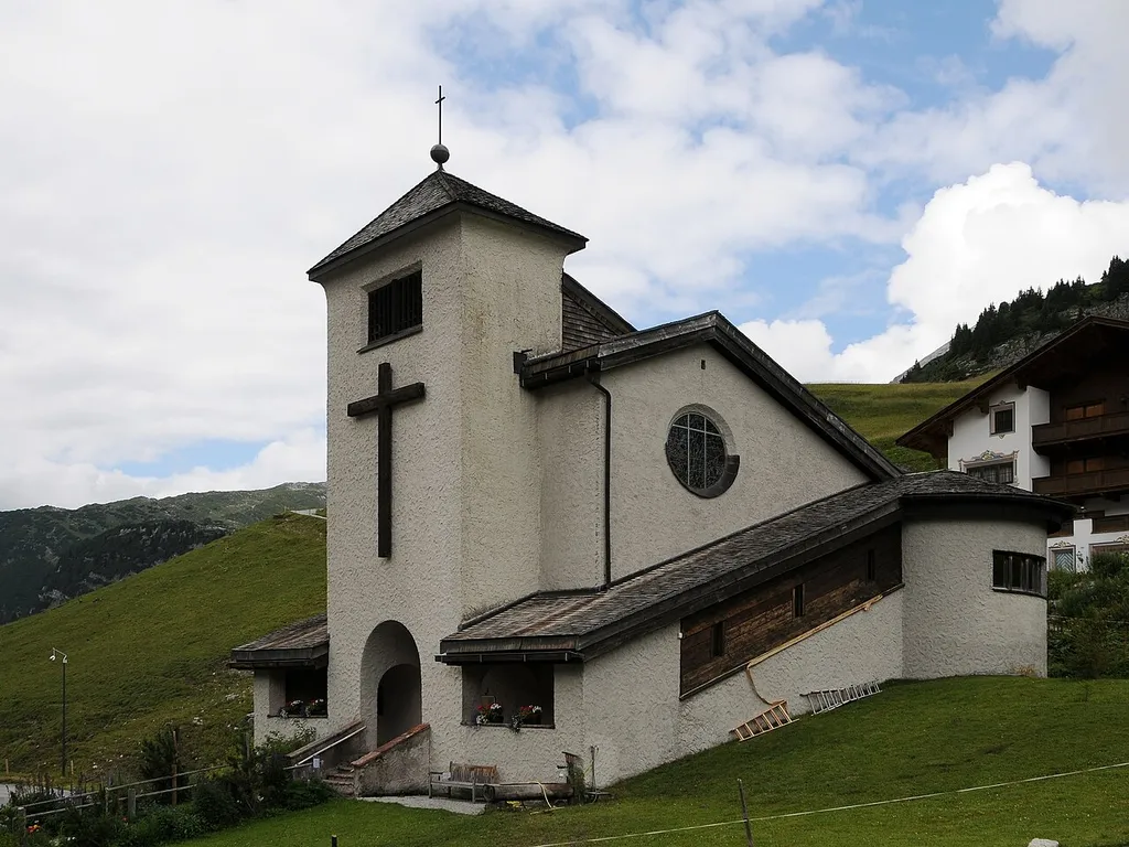 Kirche Christkönig, in Zürs am Arlberg, im Osten des Hoteldorfes. 1935/36 nach Plan von Hans Feßler erbaut. Rechteckbau mit mächtigem vorspringendem Turm und seitlicher Aufgang mit Rundbau.