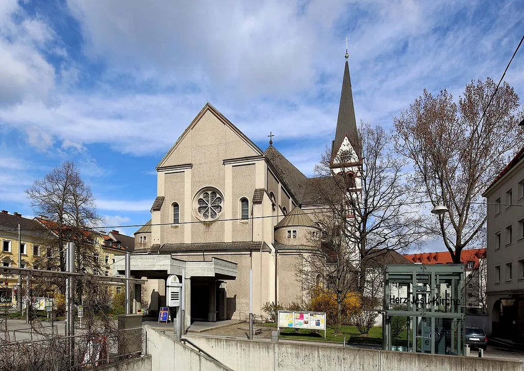 Südwestansicht der katholischen Pfarrkirche Herz-Jesu nächst Bulgariplatz (Lustenau) in der oberösterreichischen Hauptstadt Linz. Die Kirche an der Straßenecke Wienerstraße/Lissagasse ist eine romanische Stilkopie in Form einer dreischiffigen Basilika und wurde als Teil des Redemptoristen-Klosters von 1901 bis 1903 nach einem Entwurf des Architekten Raimund Jeblinger errichtet. Seit 1908 ist die Herz-Jesu-Kirche eine Pfarrkirche, die mit 15. Oktober 2009 unter Denkmalschutz gestellt wurde.