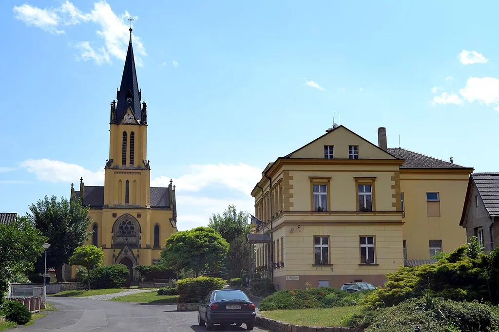 Church of the Nativity of the Virgin Mary and municipal authority building in Libochovany, Ústí nad Labem region, Czech Republic.