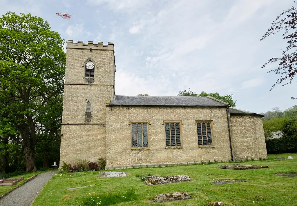 The church was built in 1832 on the site of an old Saxon church. The base of the tower is possibly mediaeval. It is built in yellow brick with a slate roof, and there is a western tower, nave, and chancel. At the east end of the church there is a polygonal apse. The tower is 44 feet high and has five bells which can all be rung by one person. The interior of the church has whitewashed walls. The tower has the entrance porch in the base and there is a gallery at the west end of the nave. The gallery was erected in 1832. The pew ends and altar rails were carved by the Reverend Townsend in the 19th century, and he is commemorated in a stained-glass window in the nave depicting Saint Nicholas. The font dates from the late 18th-century and is an octagonal bowl on a pedestal with a square base. There is a small organ which was installed in 1887. The east window was recovered from the redundant church of St John in Eton in 1991.