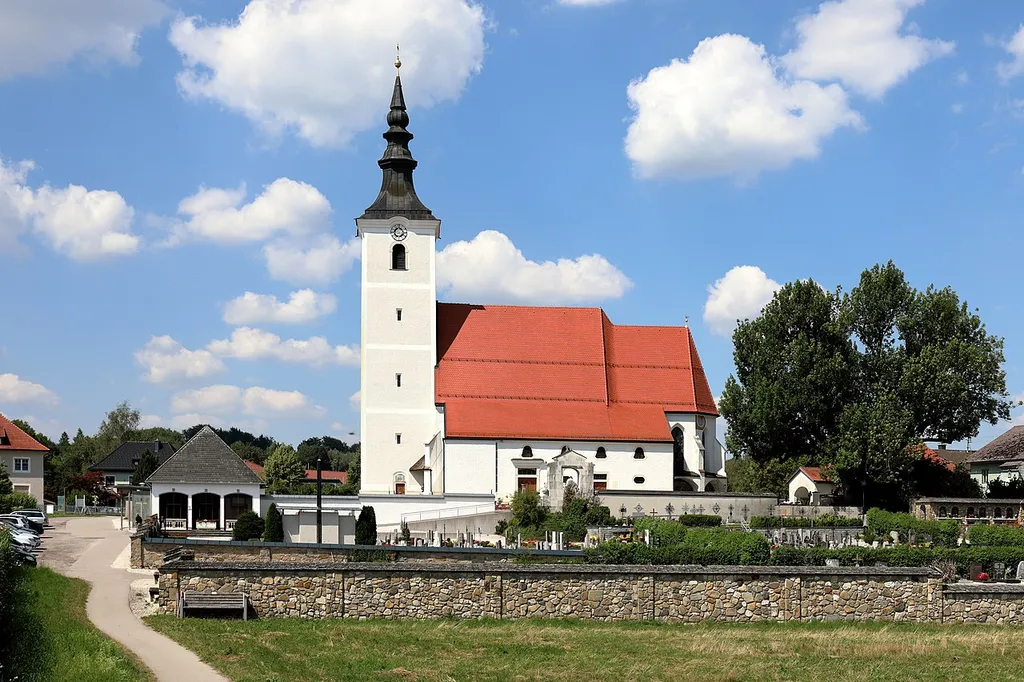 Südansicht der von einem Friedhof umgebenen röm.-kath. Pfarrkirche Hl. Jakobus der Ältere in der oberösterreichischen Marktgemeinde Seewalchen am Attersee und rechts die unter Naturschutz stehenden Friedhofsesche.Die gotische Kirche wurde Mitte des 15. Jahrhunderts errichtet und 1476 geweiht. Im 19. Jahrhundert fand eine Erweiterung des südseitigen Anbaus statt und der Turm wurde ebenfalls neu gestaltet. Von 1998 bis 2001 wurde die Pfarrkirche umgebaut, komplett renoviert und erweitert, dabei würde unter anderem nordseitig sozusagen ein linkes Seitenschiff errichtet.