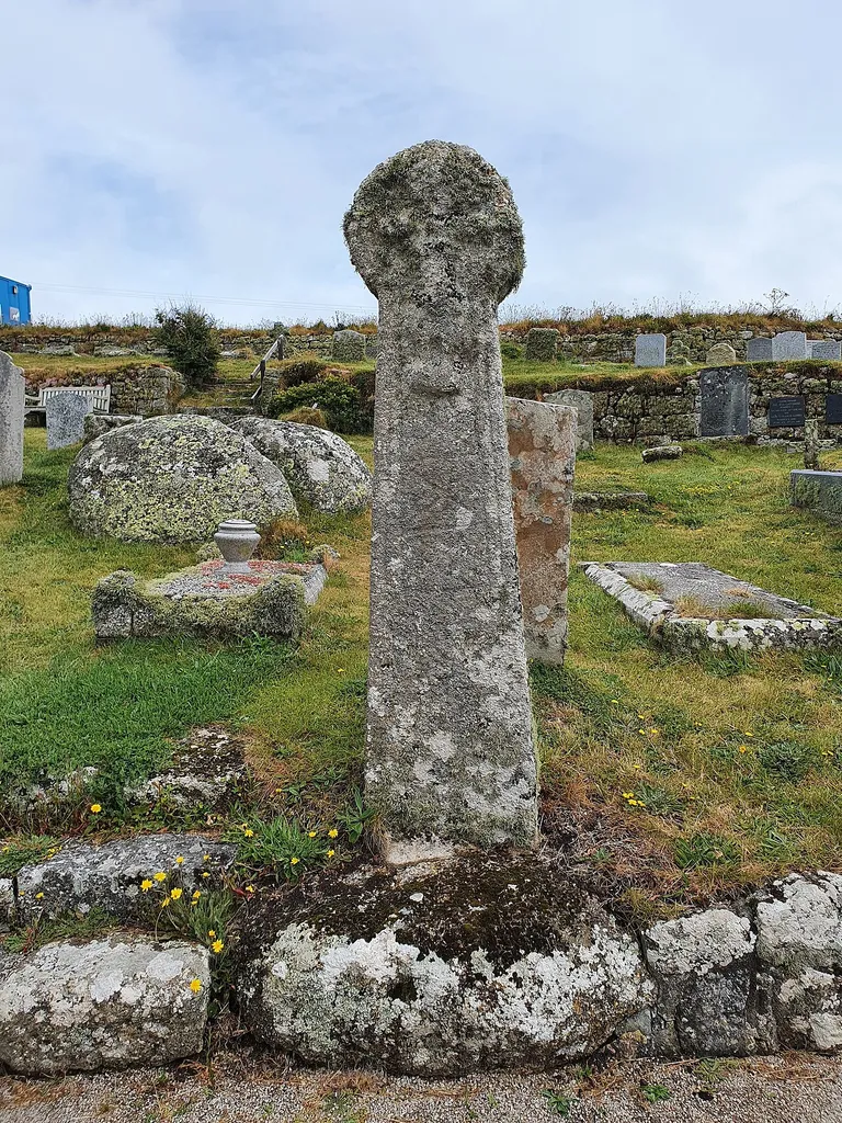Early medieval cross to the south of the Church of St Levan. St Levan's stone is in the background. This is a photo of listed building number 1143875.