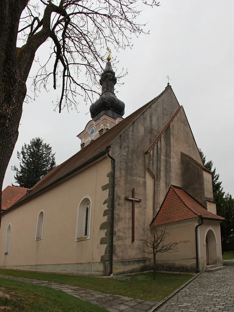 Ursprünglich einschiffige, romanische Kirche aus dem 13. Jahrhundert, mit Rechteckchor. Mitte des 14. Jahrhunderts um zwei Kapellen und das nördliche Seitenschiff erweitert. 1741 barockisiert. Zweigeschoßige Sakristei an der Nordseite von 1880.