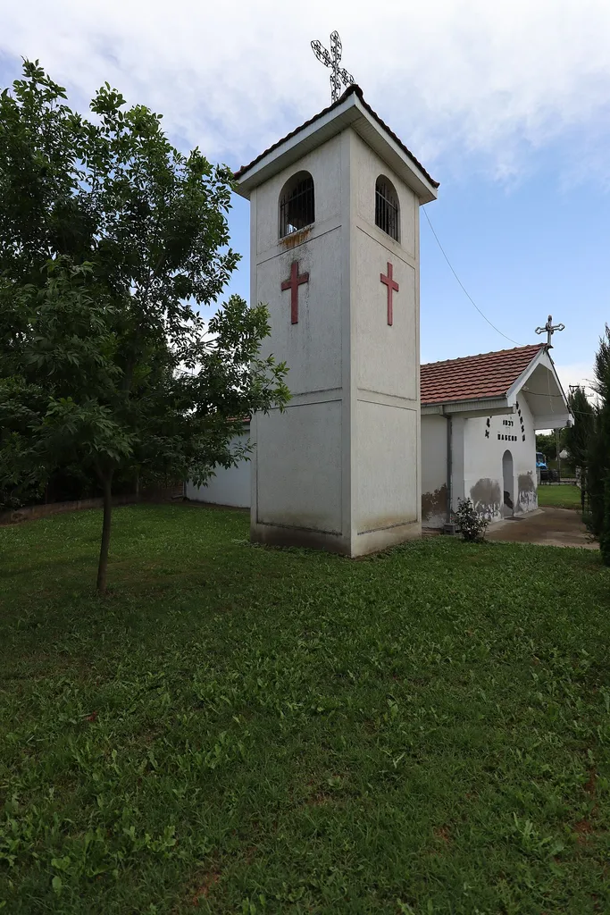 The bell tower (in front) and the St. Athanasius Church (behind) in the village of Žabeni