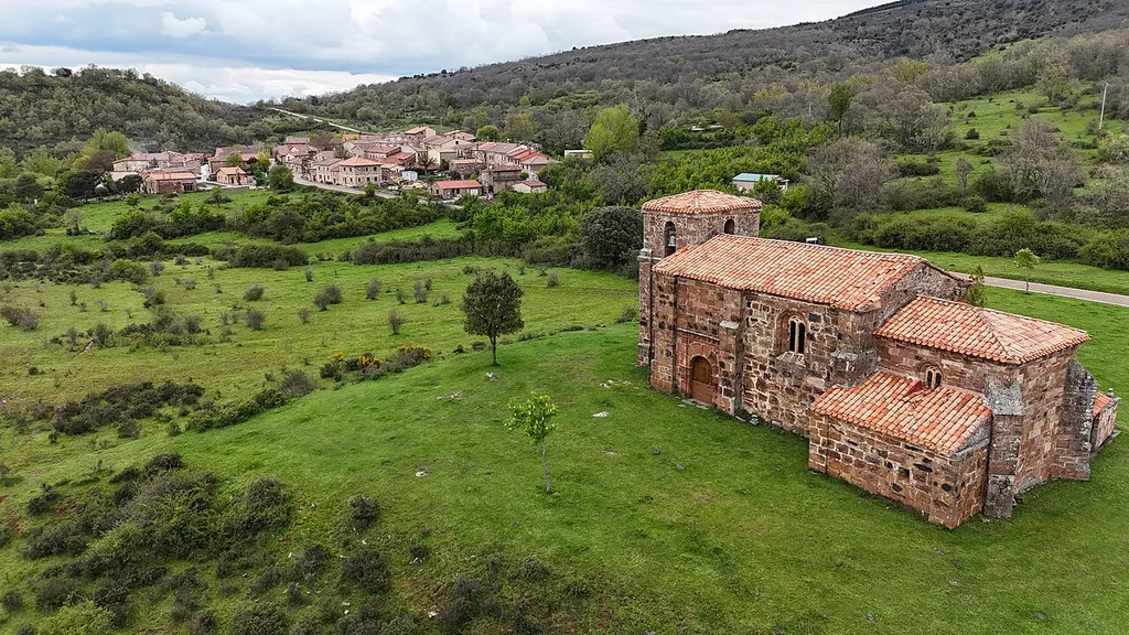 The church Iglesia de La Asunción outside the village of Villoruebo in the province of Burgos. On the left in the background is the village.
