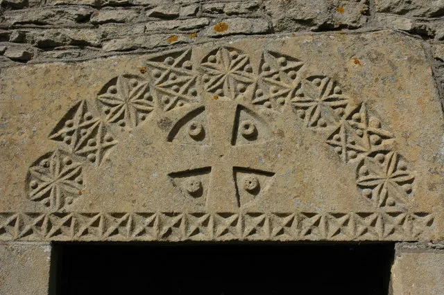 Detail from Great Washbourne Church Carved detail and a Maltese Cross from the tympanum above the south door to St Mary's church, Great Washbourne.