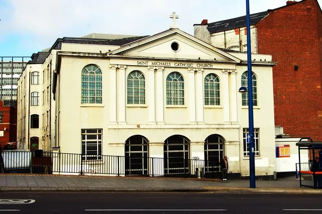 St Michael's Catholic Church in New Meeting Street, Birmingham, England was opened in 1802 as a Unitarian chapel, successor to the original New Meeting which was burned down (along with the home of its minister, the chemist Joseph Priestley) in the riots of 1791. It is designed as a simple rectangular meeting house, with a three-sided gallery supported on timber columns. The church (seen here from Moor Street) now serves the Polish community.