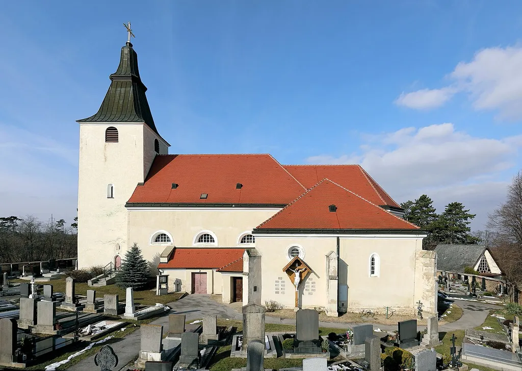 Südansicht der röm.-kath. Pfarrkirche hl. Georg in Stillfried, ein Ortsteil der niederösterreichischen Marktgemeinde Angern an der March. Eine 1669/70 barockisierte, weithin sichtbare ehemalige Wehrkirche mit einem gedrungenen Westturm aus dem 13. Jahrhundert und Ringmauer.