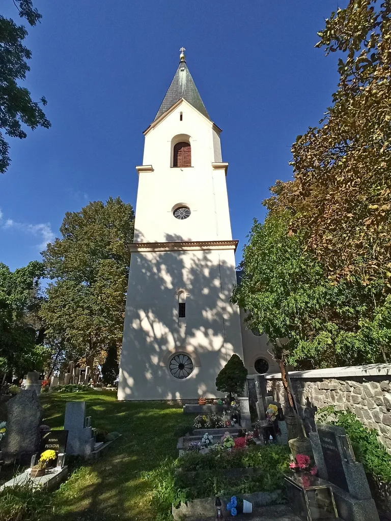 Front view from the cemetery to the tower of the Holy Trinity Church in Hluboš, Příbram district