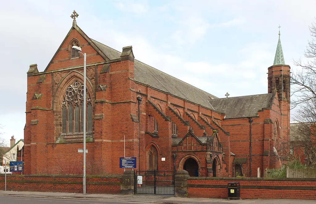 Grade II listed church on the boundary of Crosby &amp; Waterloo, by Grayson &amp; Ould, 1900. West and south side, showing flying buttresses and spire.