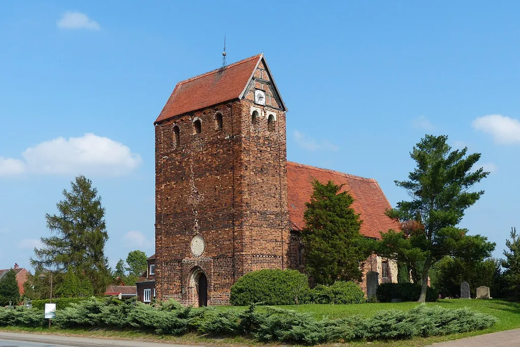 Der Wehrturm der spätromanischen Kirche (um 1220 - 1250 errichtet) nimmt die ganze Breite des Kirchenschiffes ein. Aus gutem Grund waren die Kirchen so beschaffen, denn Rückeroberung durch die Slawen drohte den östlich der Elbe gelegenen Landstrichen mit ihren noch jungen Christengemeinden. Die Lage der Kirche auf einem flachen Hügel - immerhin der höchsten Stelle des Dorfes - bewahrte sie 2013 vor dem gewaltigen Hochwasser der Elbe, das Fischbeck infolge eines Deichbruchs zu großen Teilen flutete.
