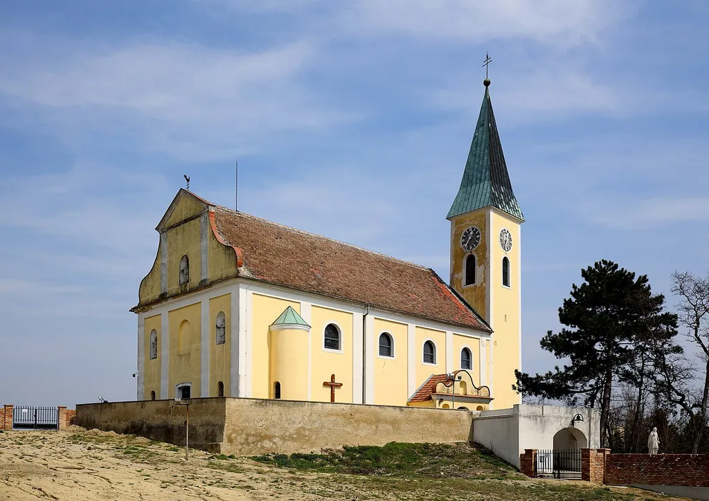 Südwestnsicht der katholischen Pfarrkirche hl. Nikolaus in der niederösterreichischen Marktgemeinde Großebersdorf. Eine barocke Kirche in erhöhter Lage mit einem gotischen Chor und einem Südturm um 1400. Im Jahr 1908 wurde das Langhaus um zwei Joche Richtung Westen erweitert.