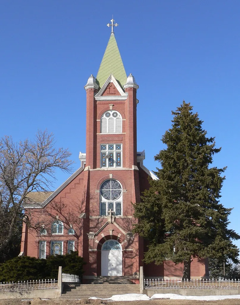 Visitation Church in O'Connor, Nebraska; seen from the south. O'Connor is an unincorporated settlement in Greeley County southeast of the village of Greeley. The church, rectory, and parish hall make up the Visitation Church complex, which is listed in the National Register of Historic Places. The church was designed in Romanesque Revival style by architect James H. Craddock, and was built in 1904.
