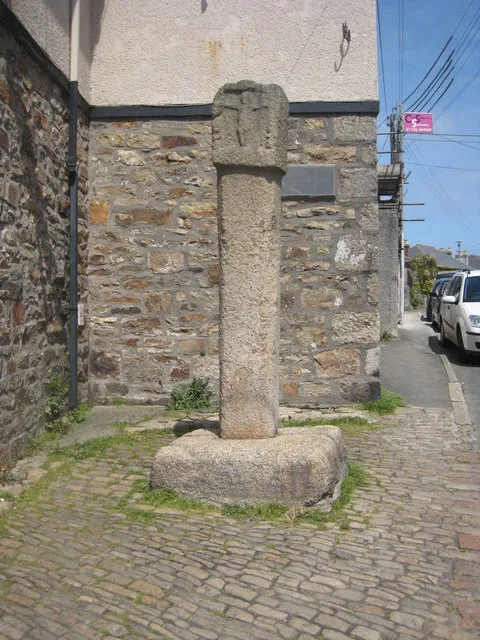 Ancient cross in St Erth Situated next to the post office. The slate plaque on the wall reads 'This site is dedicated to the parishioners of St Erth and entrusted to their care by John Lord St Levan Lord of the Manor of Treloweth in this parish 1891'.