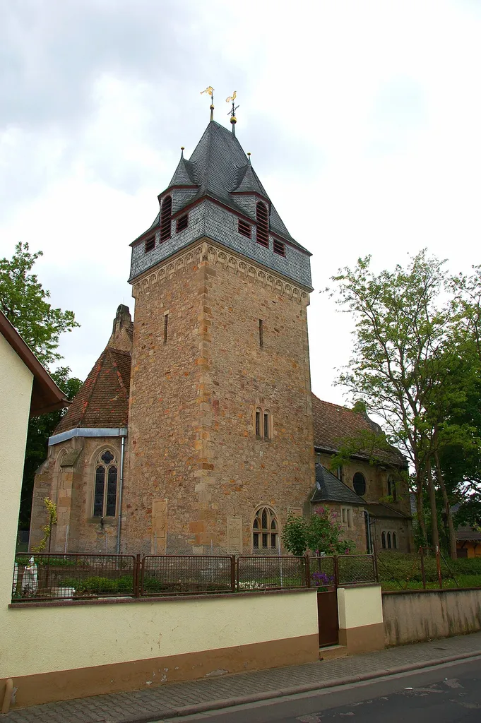 Dreischiffiger späthistoristischer Bruchsteinbau, 1903/04, Architekt Ludwig Hofmann, Herborn, teilweise mit spätgotischen und barocken Mauerteile und im Kern mittelalterlichem Chorflankenturm. Barockportal im Westen, bezeichnet 1749. Von der alten Kirche ist noch das spätgotische Sakramentshaus erhalten. Die Orgelbauerfamilie Stumm errichtete 1775 die Orgel der Kirche.