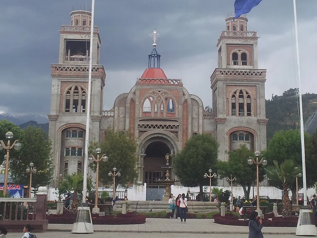 Vista de la Plaza de Armas de Huaraz, con la Catedral en construcción y las banderas de Perú y Huaraz.